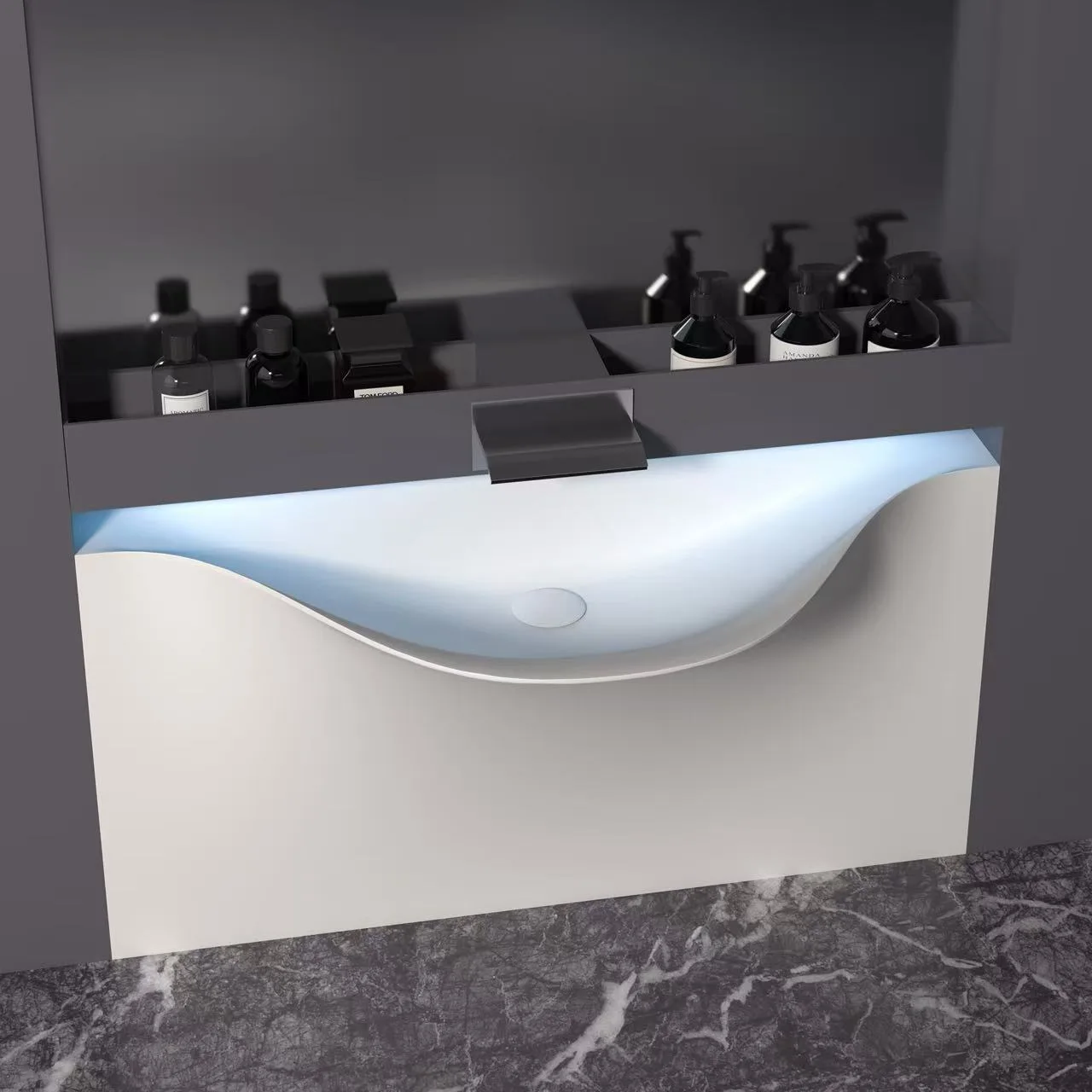 A matte white sculptural solid surface sink installed in a dark, luxury commercial alcove with architectural LED backlighting.