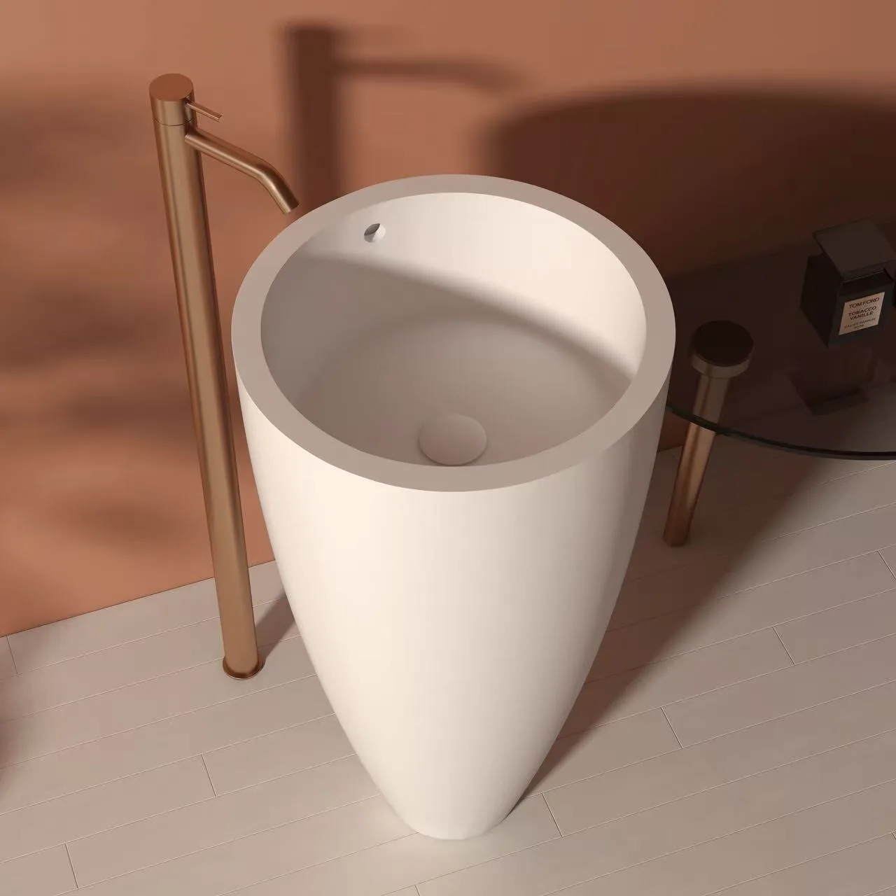 High-angle view of a matte white tapered freestanding solid surface sink highlighting the integrated overflow hole and floor-mounted faucet.