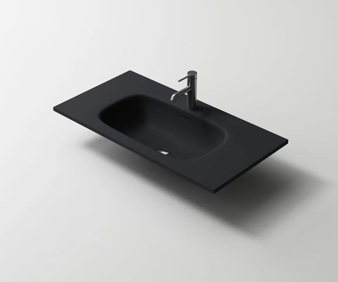Modern matte black solid surface washbasin with a seamless integrated bowl for boutique hotel designs.
