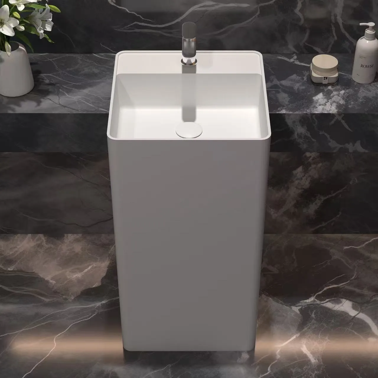 Close-up detail of a commercial-grade wall mount solid surface sink showcasing the integrated towel rack and smooth basin curves.