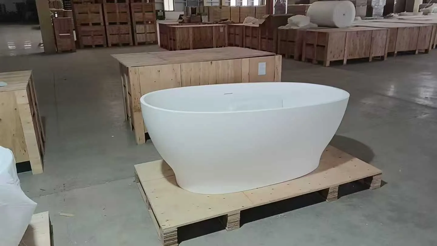 Factory floor view showing the pre-installed drainage and solid underside of a HONDAO freestanding solid surface bathtub.