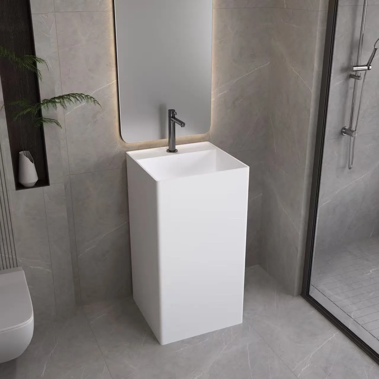 Matte white contemporary pedestal sink complementing a minimalist shower enclosure in a high-end hospitality environment.