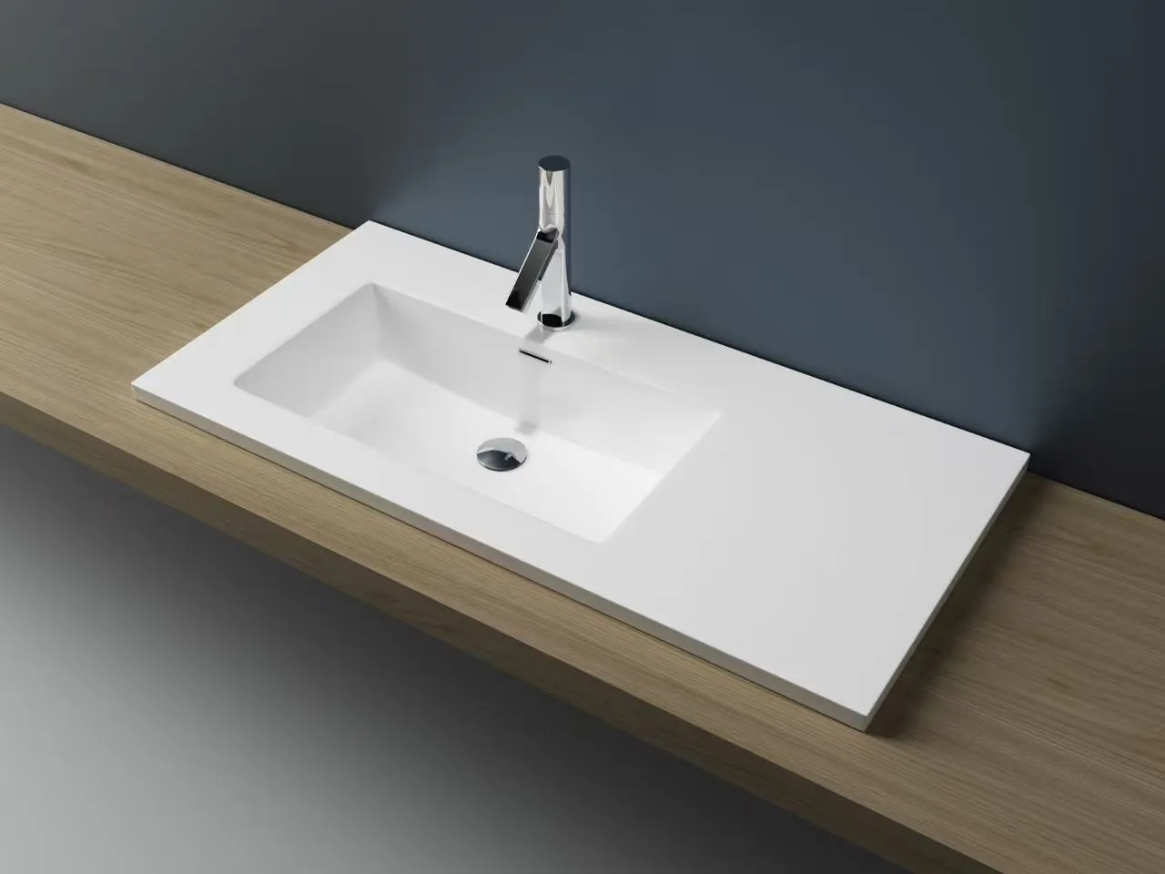 Isometric view of an asymmetrical solid surface vanity sink featuring a left-aligned bowl and extended right-side deck.