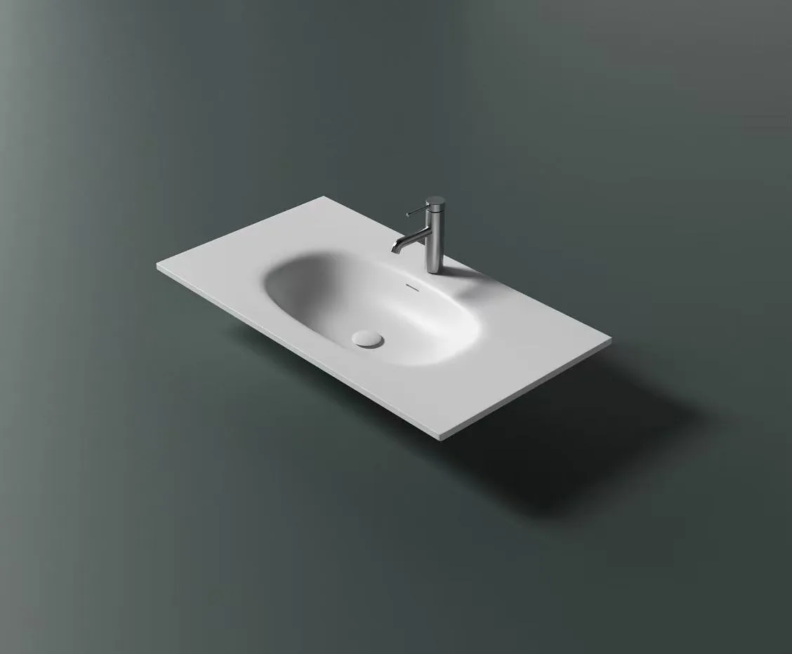 Minimalist white cast stone single basin vanity top shown against a dark architectural background.