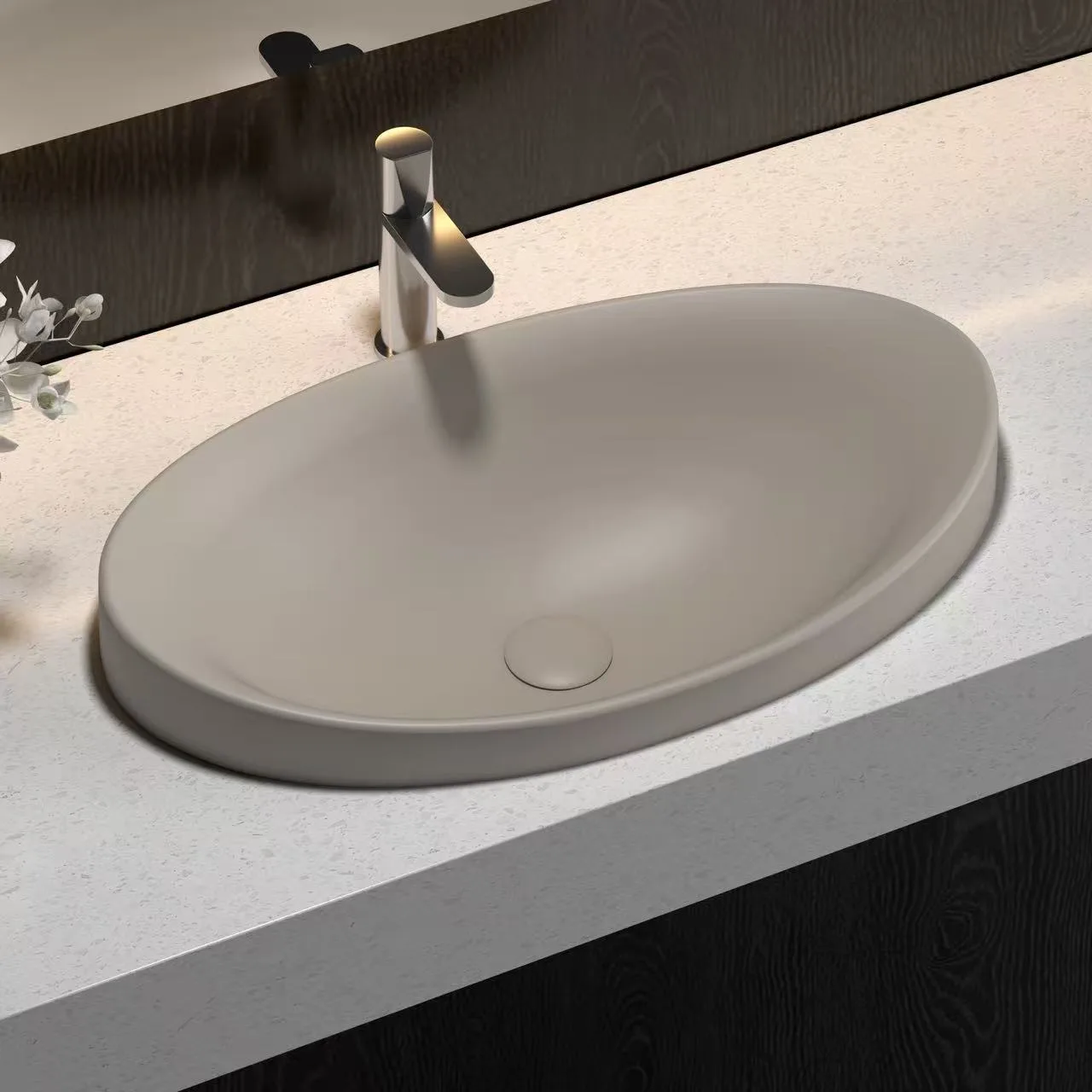 Matte black oval solid surface sink providing a striking architectural statement for avant-garde hotel washrooms.