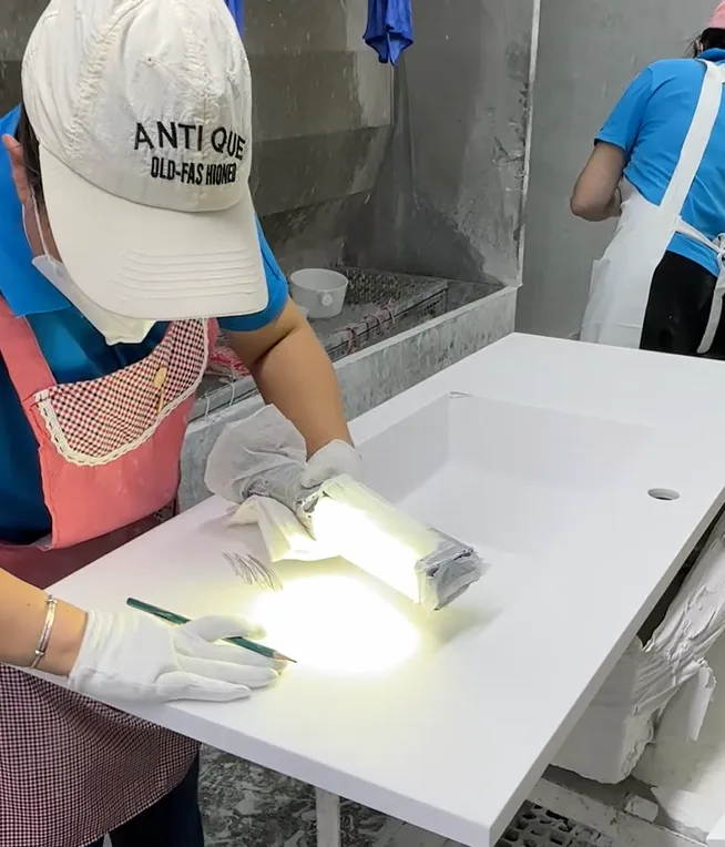 Rigorous QC inspection using lumen-grade lighting to detect microscopic subsurface defects in HONDAO custom solid surface sinks.