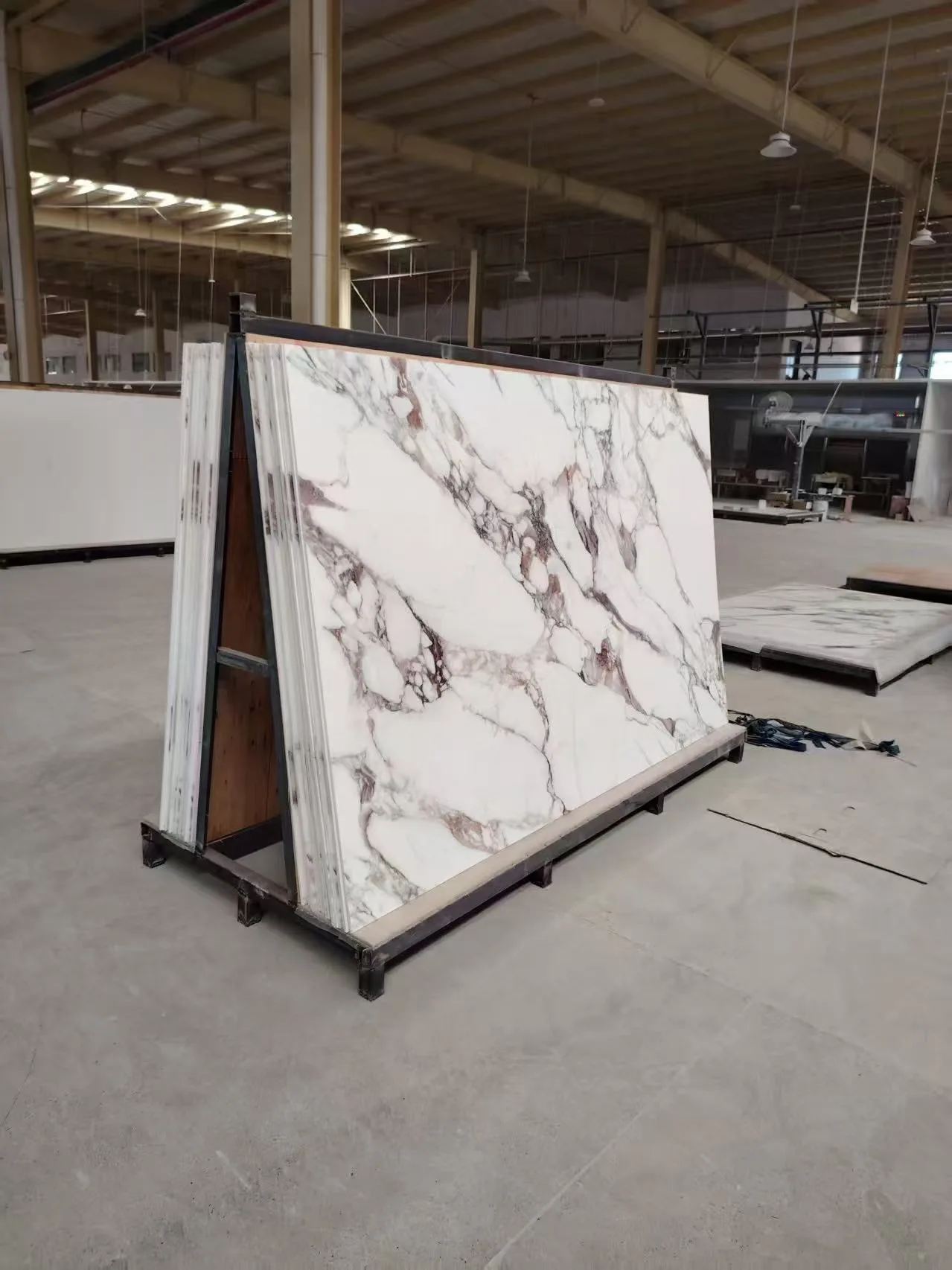 Massive slabs of cultured marble shower wall panels stored on heavy-duty A-frames in the HONDAO manufacturing facility.Artificial Stone Shower Wall Panels