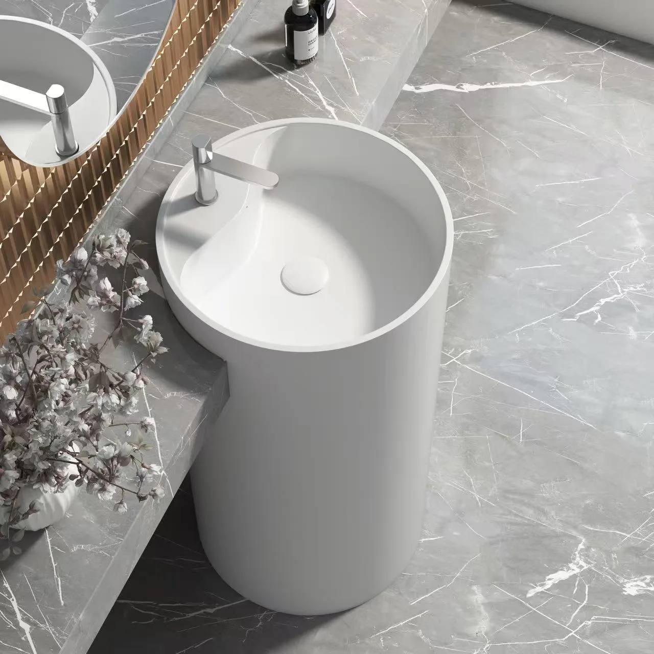 A minimalist freestanding cylindrical Artificial Stone Washbasin pillar against a luxury marble wall.
