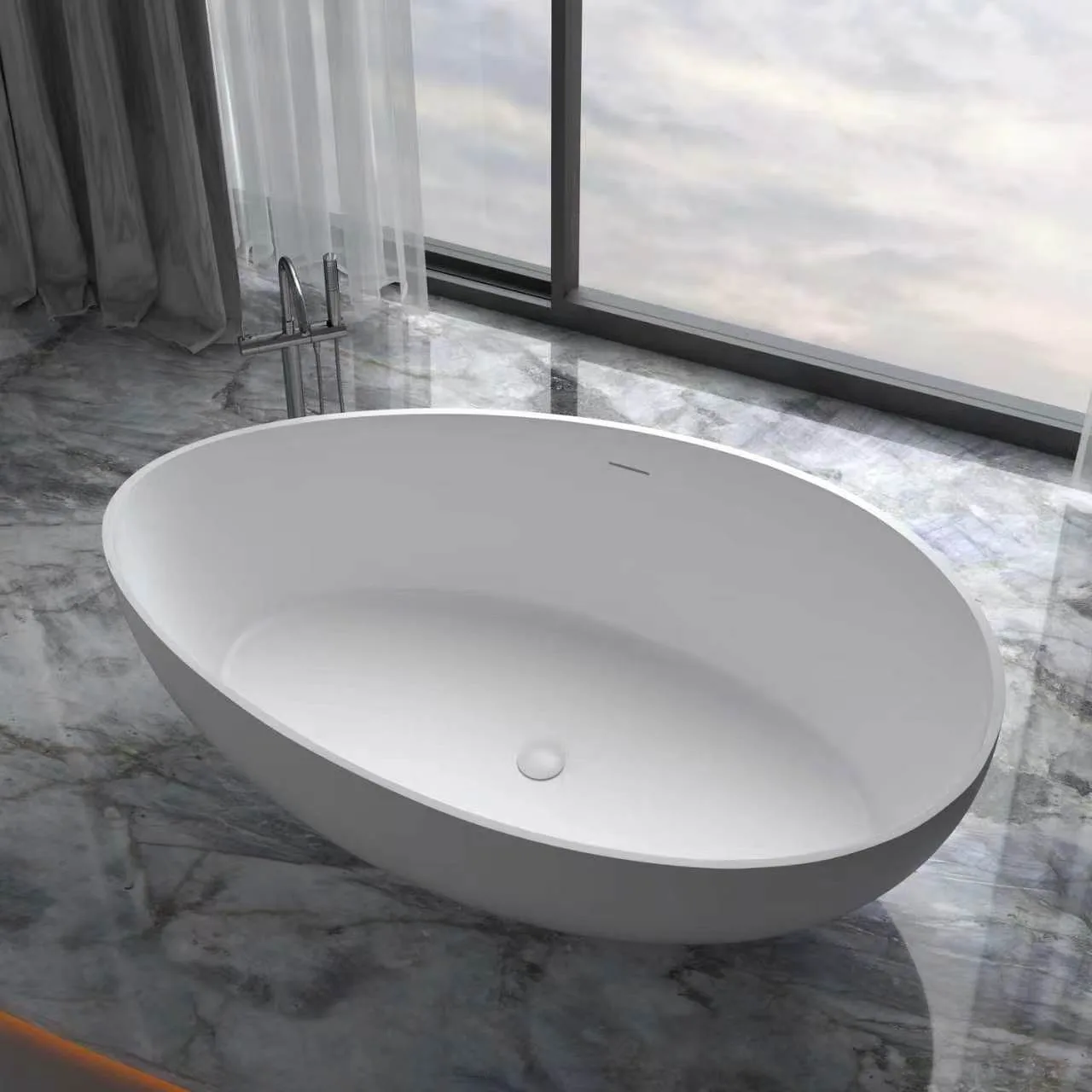 High-angle view of a premium matte white solid surface freestanding bathtub with an undulating curved rim, placed on a grey marble floor next to a floor-mounted faucet.
