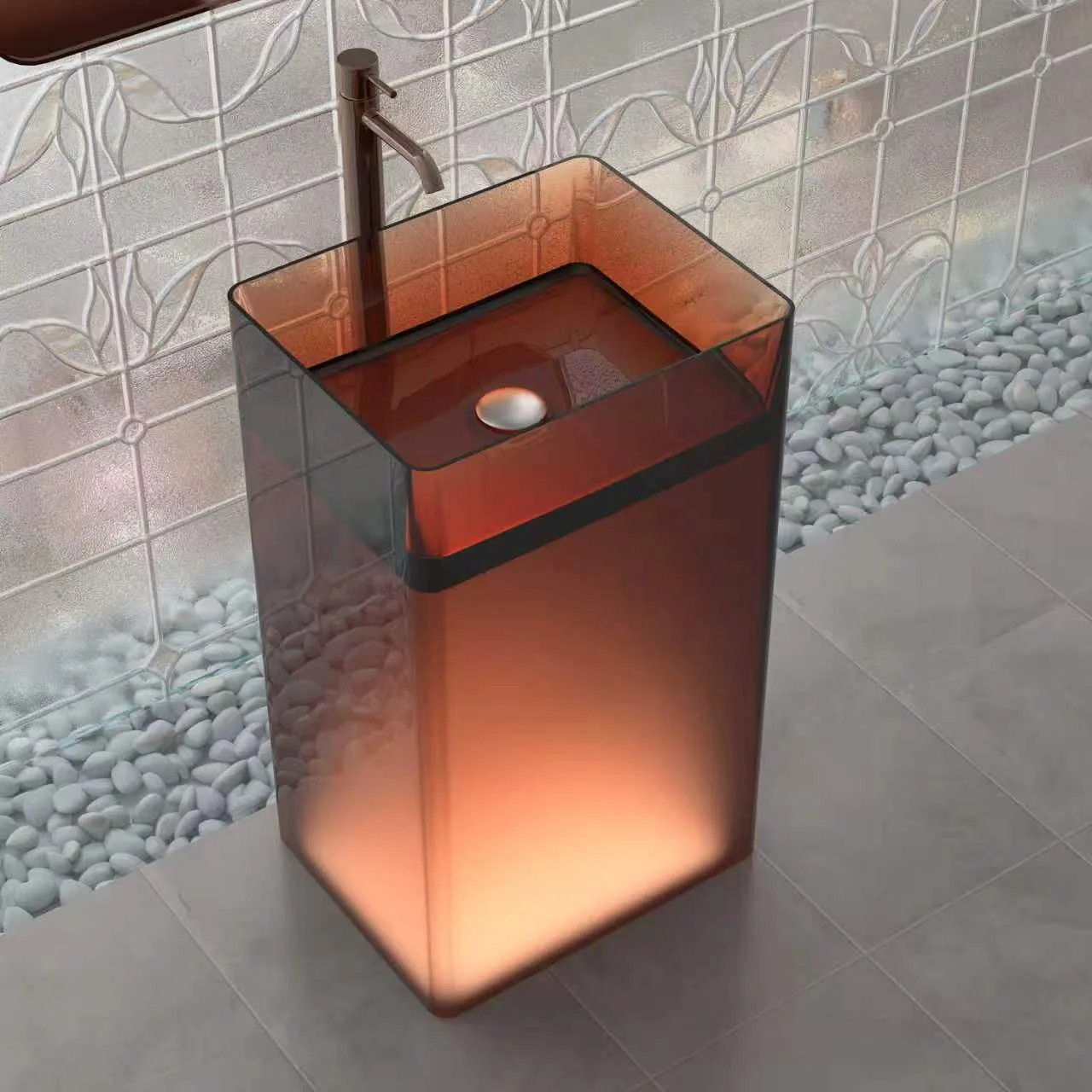 High-angle perspective view of the amber illuminated translucent resin pedestal washbasin showing the internal drainage basin and soft radiant illumination.