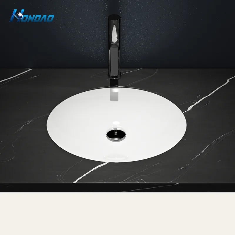Matte White Solid Surface Elliptical Undermount Basin top-down installation view beneath black marble vanity countertop paired with matte black faucet.