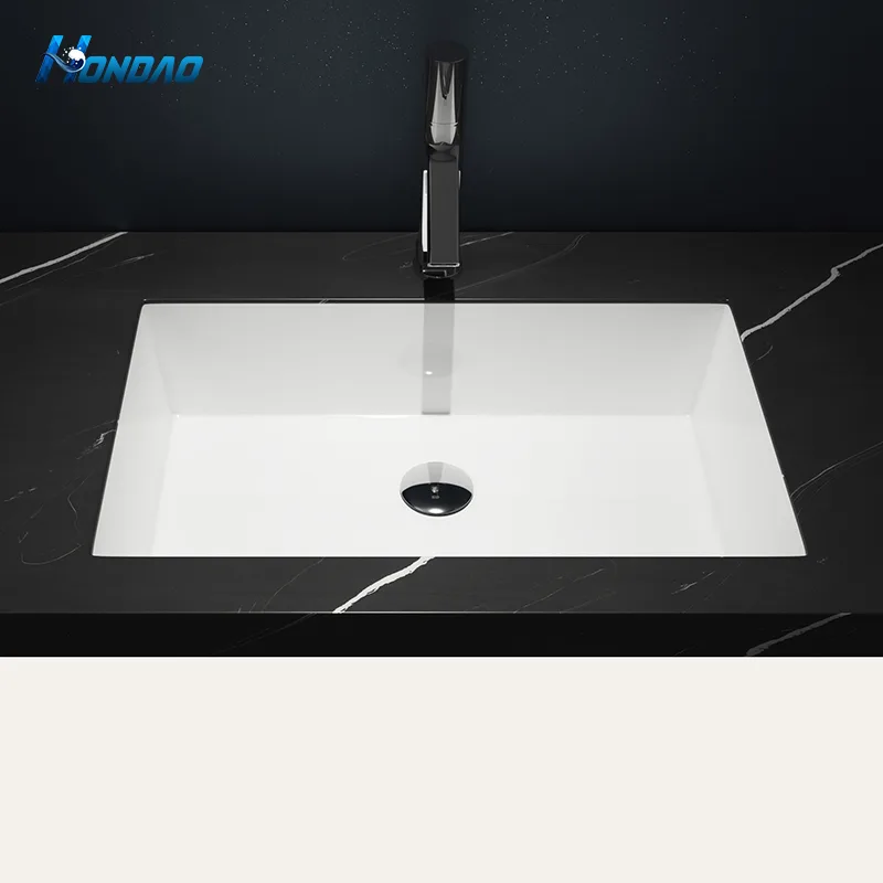 Matte White Solid Surface Rectangular Undermount Basin top-down installation view beneath a black marble vanity countertop paired with a modern high-spout faucet.